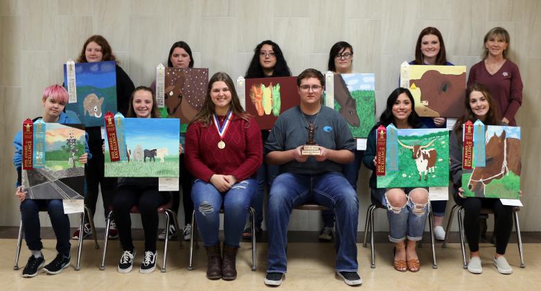 Several of the art show winners with their ribbons alongside teacher Betsy Kaufman.