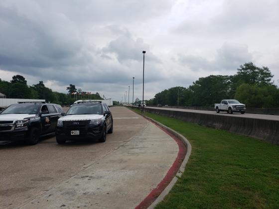 Texas DPS troopers at the Texas-Louisiana border while Louisiana travelers pass by.
