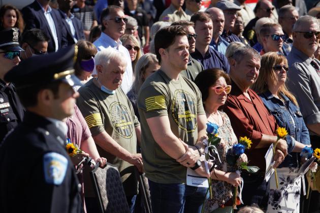 Tyler Powell (center, green shirt) honors fallen BPD officers, including his late wife, Officer Sheena Yarbrough-Powell.