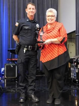 Port Arthur Police Detective Mike Hebert presents Jody Holton with a Crime Stopper of the Year award.