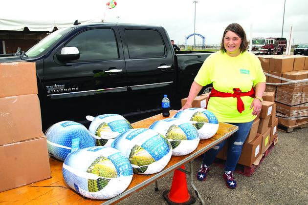 A volunteer looks on at several frozen turkeys given out at Bicycles and Bibles