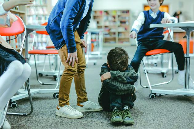 A child huddled while being bullied