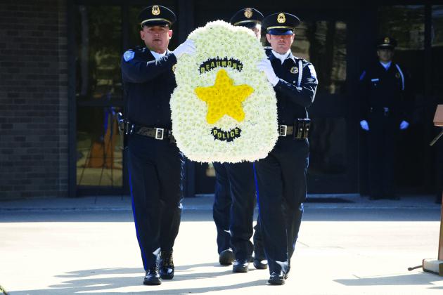 Beaumont Police officers carry a memorial wreath 