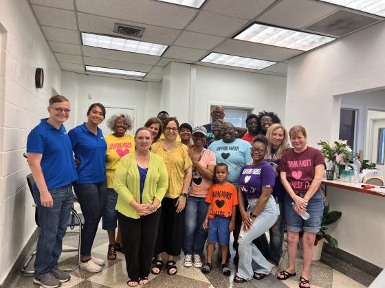 Surviving parents members pose with 12 news employees