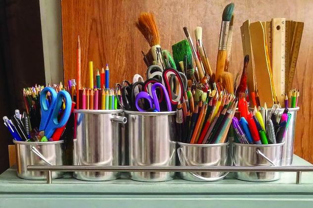 Various art supplies in metal containers