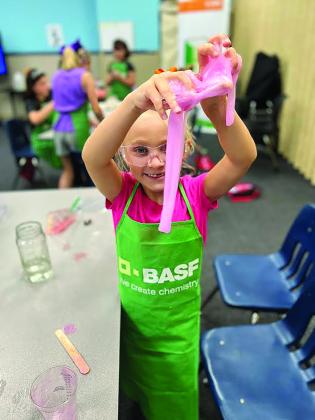 A child holds up slime created in a science experiment
