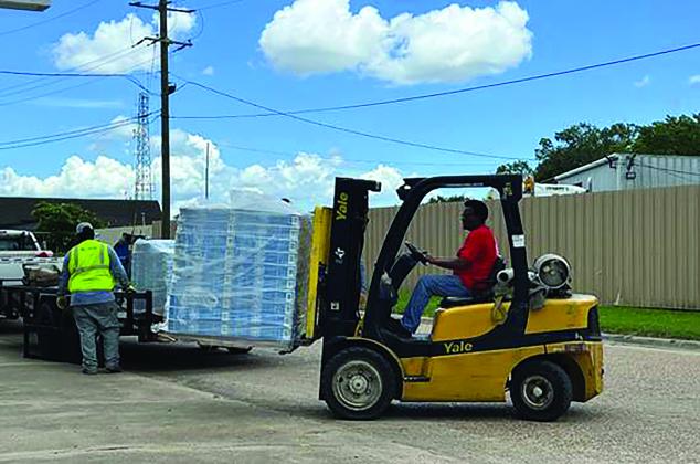 A forklift carrying boxes of fans
