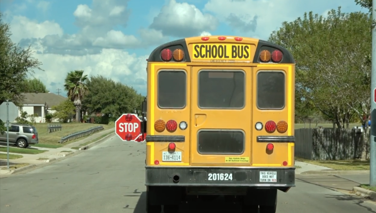 A school bus parks with a stop sign open 
