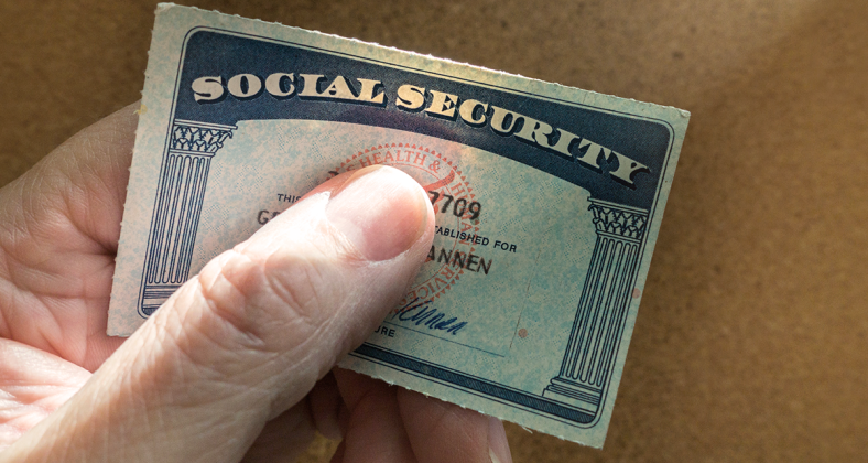A hand holds a Social Security card 