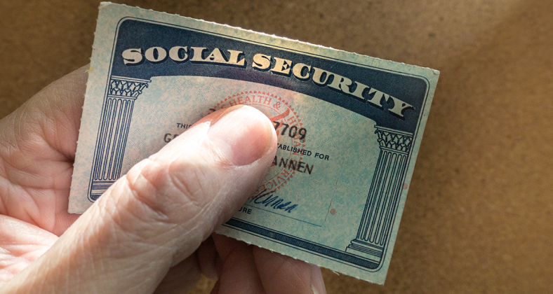 A hand holds a Social Security card