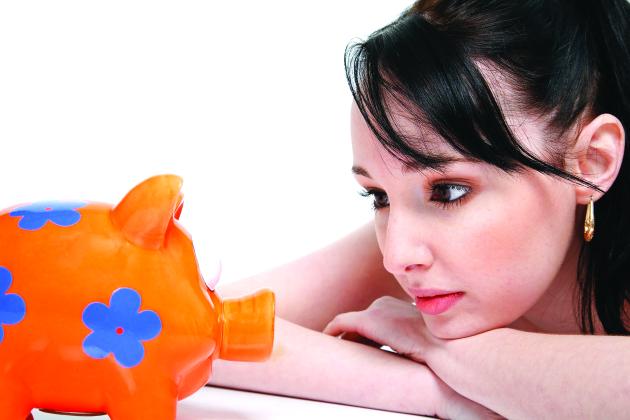 Woman looks at a piggy bank 