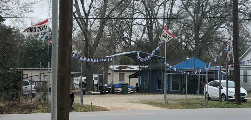 A car lot owned by the self-produced 'prominent businessman,' who others refer to as a 'slumlord'
