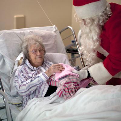 Santa with an elderly woman in bed