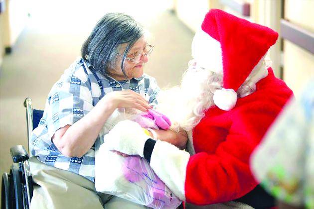 An elderly woman smiles with Santa 