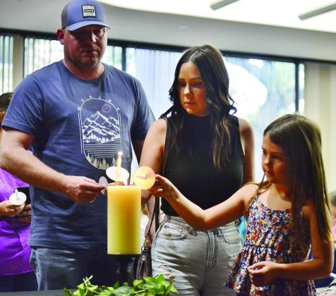 Survivors share from a single flame at the 2023 Crime Victims Vigil in Jefferson County. Photo by John Fulbright