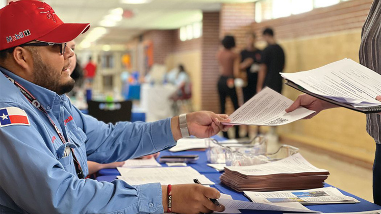 ExxonMobil employee Sergio Guzman assists Beaumont ISD parents and students with running start at Early College High School.