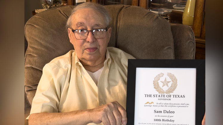 Sam Daleo holds a certificate of appreciation from Gov. Greg Abbott.