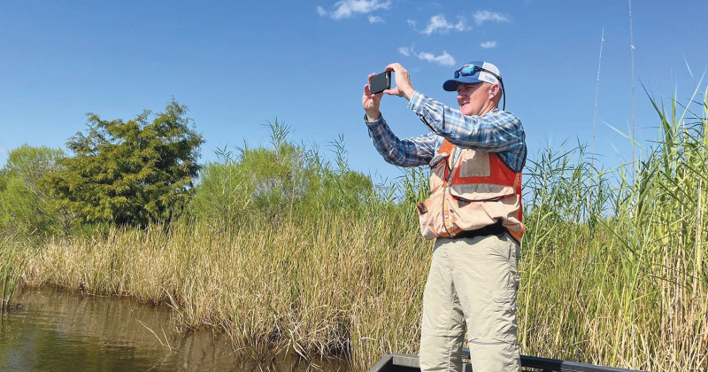 Anthony Castilaw with Castilaw Environmental Services, LLC, takes a photograph of the new property purchased by BTNHT.