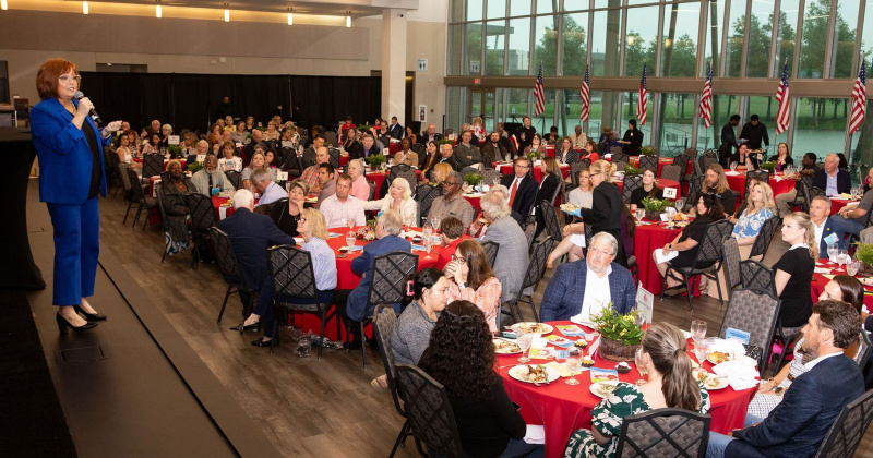 Janci Kimball, CEO of Nutrition and Services for Seniors, addresses attendees at the 13th annual Deliver the Difference Luncheon, emphasizing the importance of community support for programs like Meals on Wheels and thanking the volunteers and donors that make it all possible.