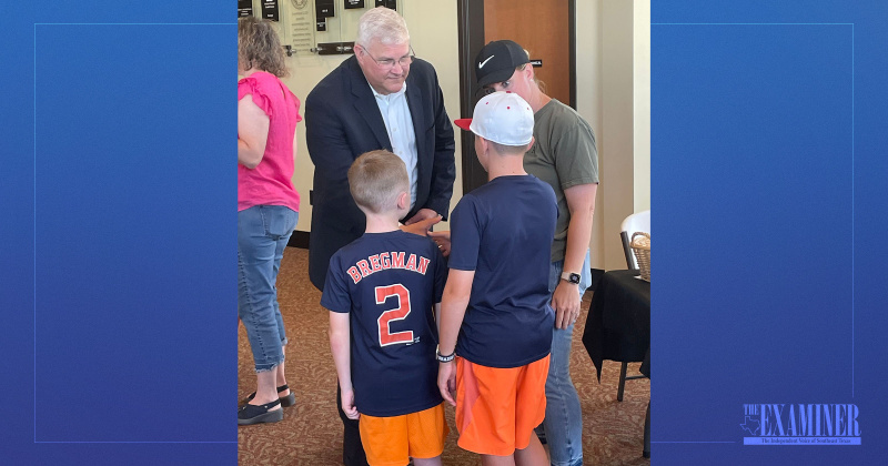Superintendant Dr. John Mathews shakes hands with a pair of LISD students.
