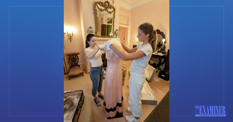 Tamez and McAtee dress a mannequin for display.