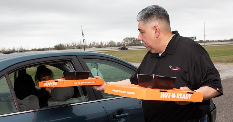 Carlos Hernandez hands out burritos from Carlito’s and pizzas from Little Caesars.