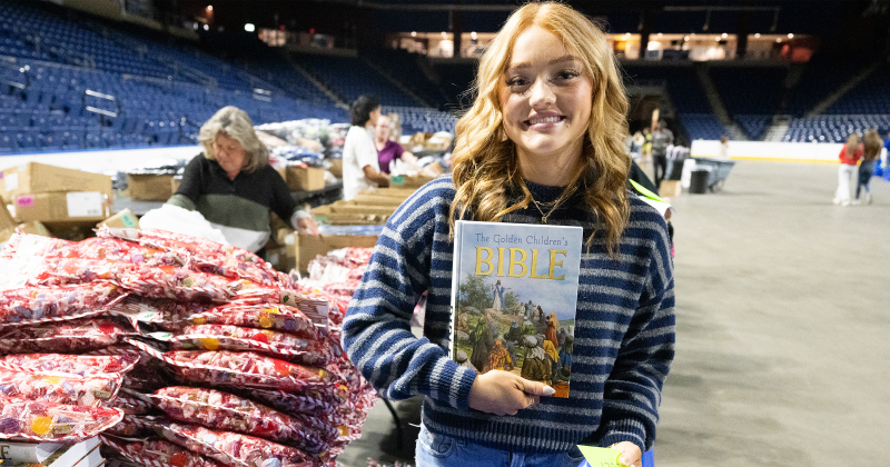 Volunteers hand out Children’s Bibles, among other gifts.