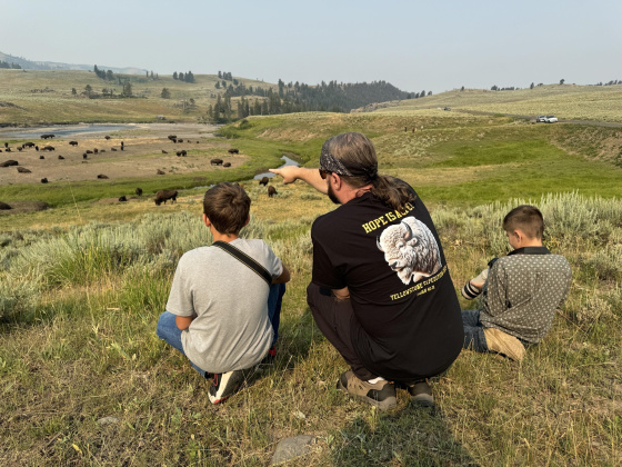 Moore shows two boys how to photograph bison in the Lamar Valley of Yellowstone National Park.